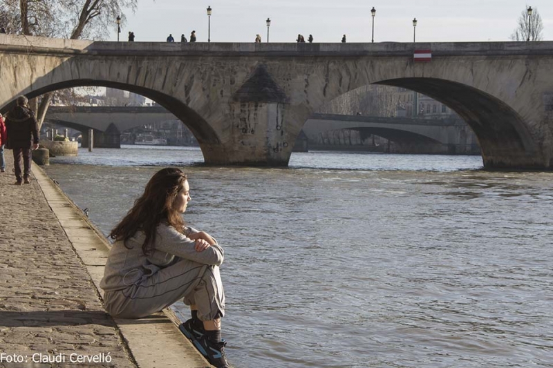 Jeune femme sur quai en bord d'un fleuve