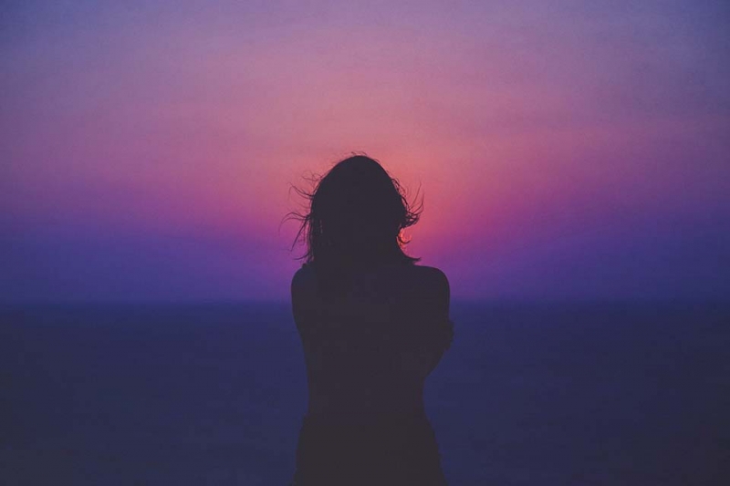 Silhouette d'une femme avec ciel rose et violet
